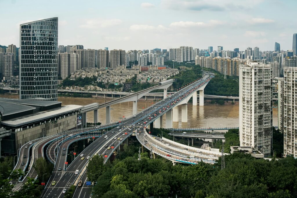 chongqing car rental with driver. Aerial shot of Chongqing's urban skyline featuring modern skyscrapers and winding highways.