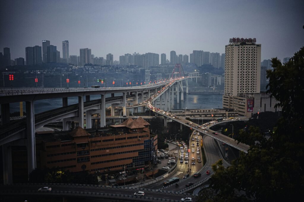 Dramatic evening view of Chongqing city skyline featuring a busy urban bridge.