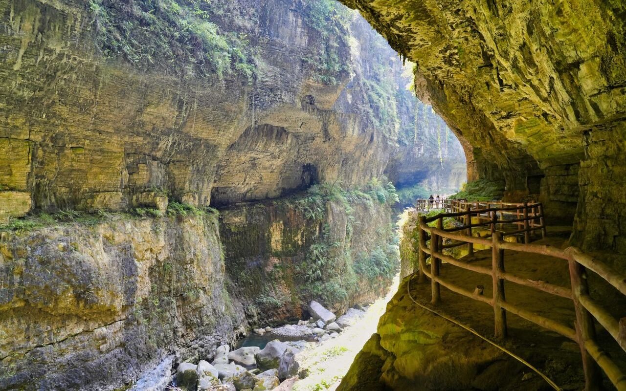 Explore a stunning rocky canyon with a wooden walkway and vibrant green foliage, perfect for nature enthusiasts.