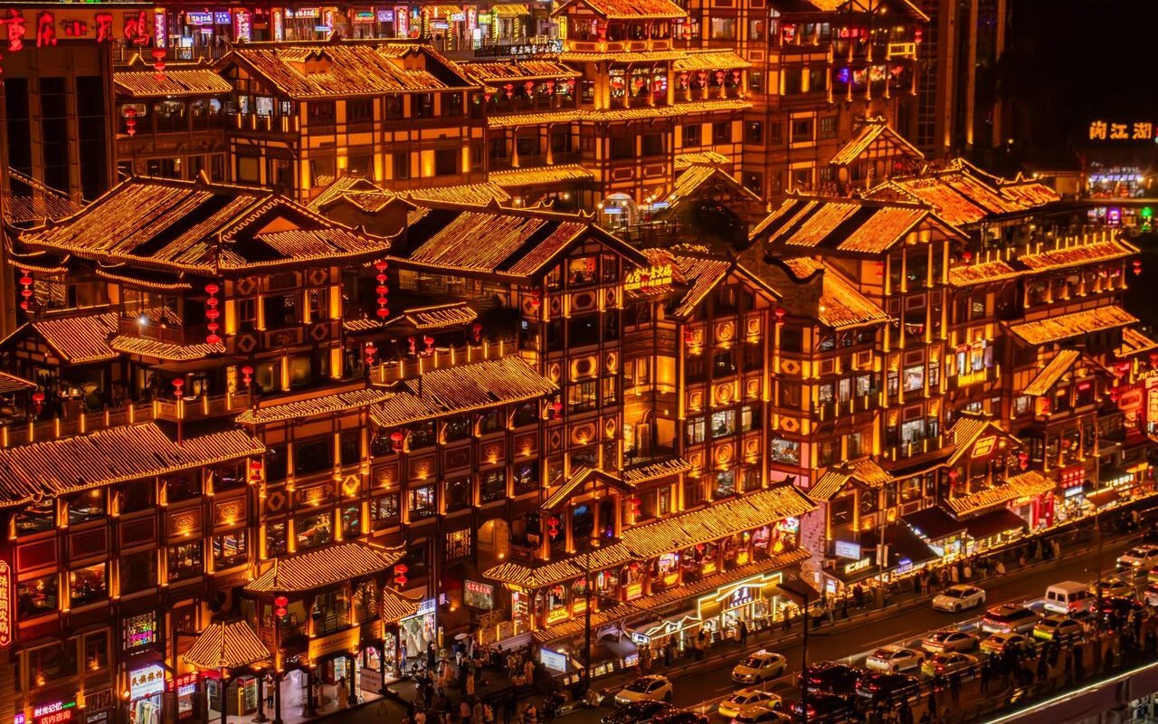 Brightly lit traditional Chinese buildings at night in Chongqing showcasing vibrant urban life.